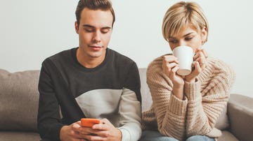 Mujer mirando pantalla de móvil de la pareja