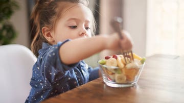 Niña tomando fruta