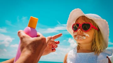 Poniendo crema solar a una niña